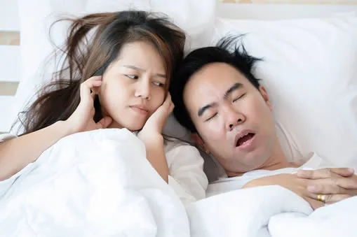 couple in bed man snoring with sleep apnea